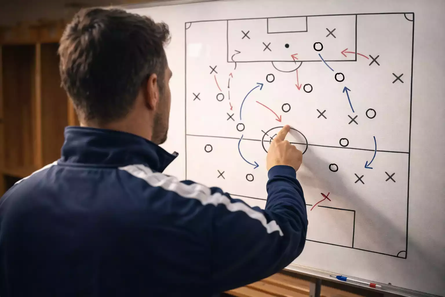 Allenatore che analizza la lavagna tattica nello spogliatoio